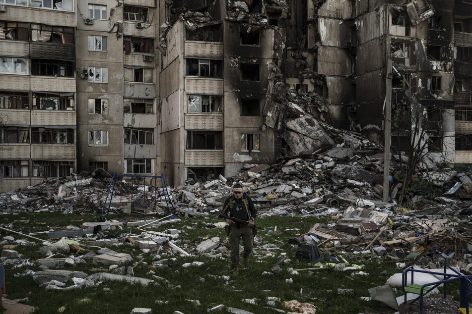 Ein ukrainischer Soldat geht inmitten der Trümmer eines Gebäudes in Charkiw, das durch russischen Beschuss schwer beschädigt wurde. In der Region wurden erneut Tote und Verletzte beklagt.