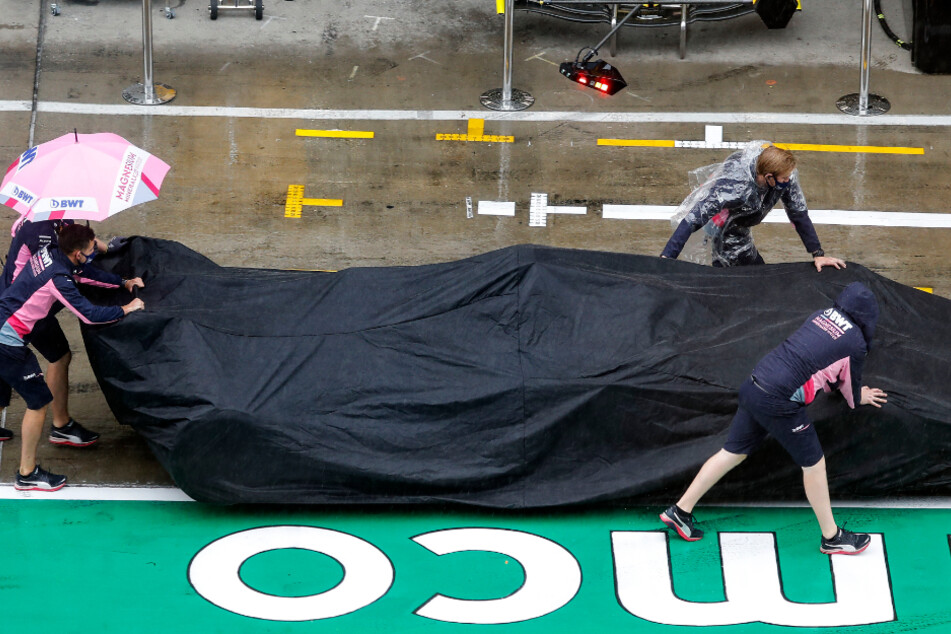 Der Rennwagen von Perez vom Team Racing Point wird unter einer Abdeckung über die Boxengasse geschoben.