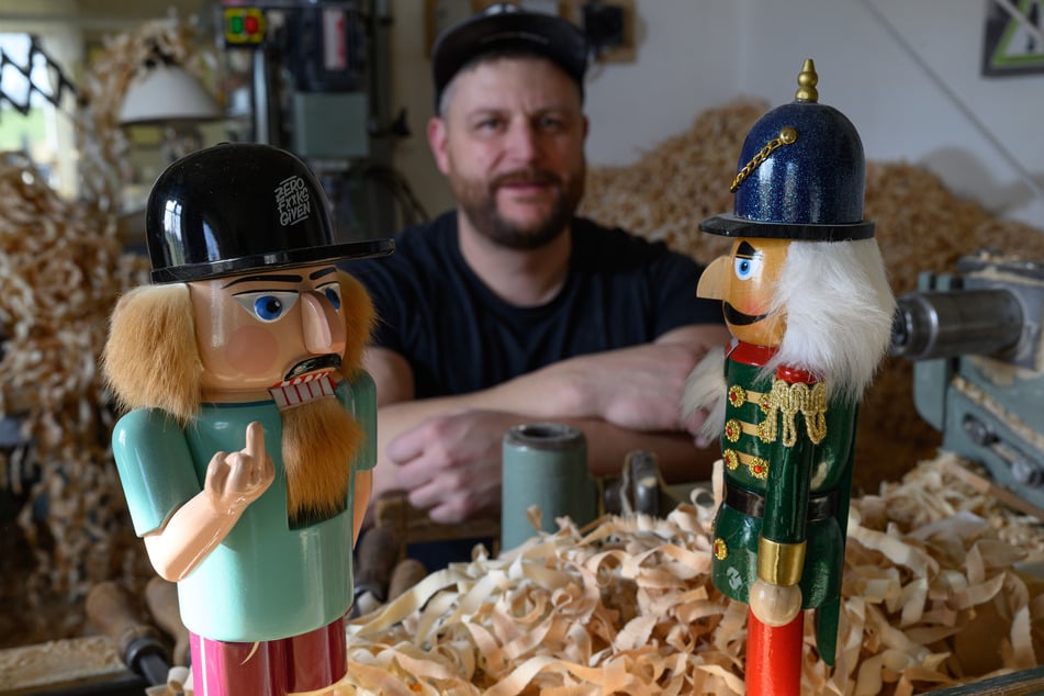 Der echt erzgebirgische Nussknacker (l.) aus der Werkstatt von Markus Füchtner (M.) zeigt der Billigkopie aus China (r.) den "Stinkefinger".