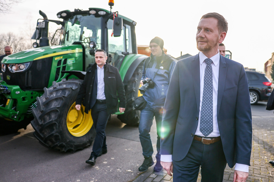 Sachsens Ministerpräsident Michael Kretschmer (48, CDU, r.) spricht vor der auswärtigen Kabinettssitzung mit den Teilnehmern einer Bauerndemonstration.