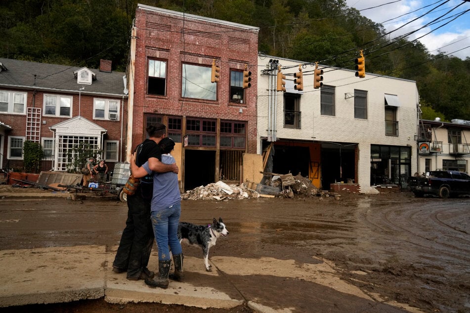 Resident Anne Schneider hugs her boyfriend Eddy Sampson as they survey the damage left behind by the tropical storm.