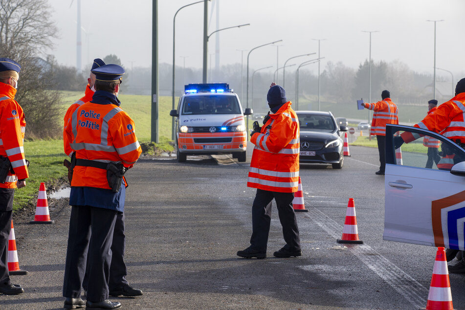 Belgien, Brüssel: Polizisten halten während einer Kontrolle am Parkplatz Aire de Hondelange an der Autobahn E411 ein Fahrzeug an.