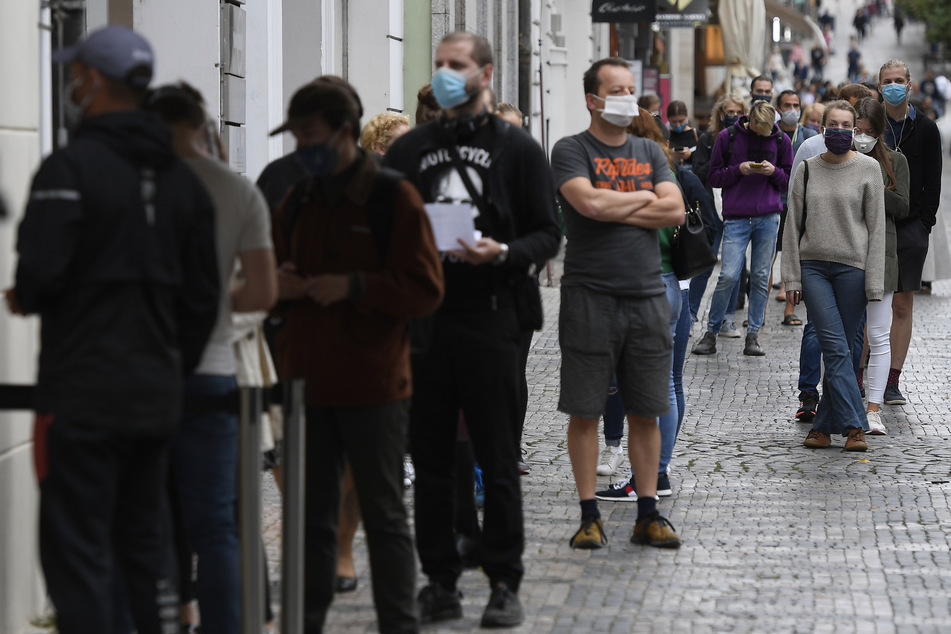 Menschen mit Mundschutz stehen an der Sammelstelle am Wenzelsplatz Schlange, um sich auf Covid-19 testen zu lassen.