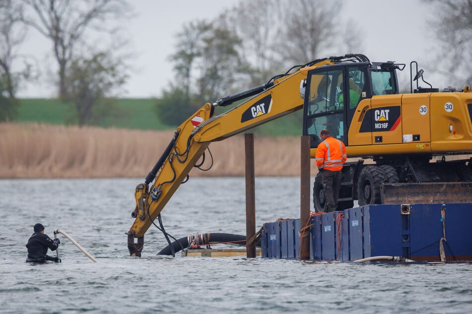 Mit einem Bagger wird eine Art Kanal ausgegraben.