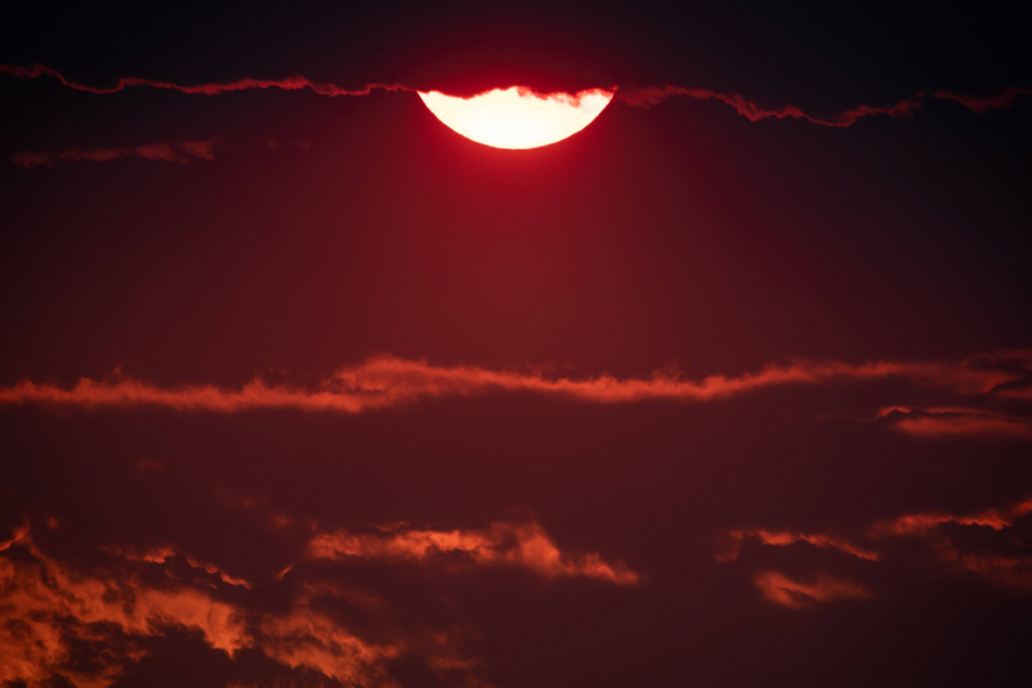 Smoke particles from burning western wildfires also enhanced the color of the sun in Canada earlier this week.