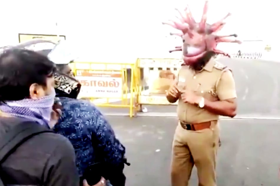 Der Polizist Rajesh Babu trägt einen Corona-Helm.