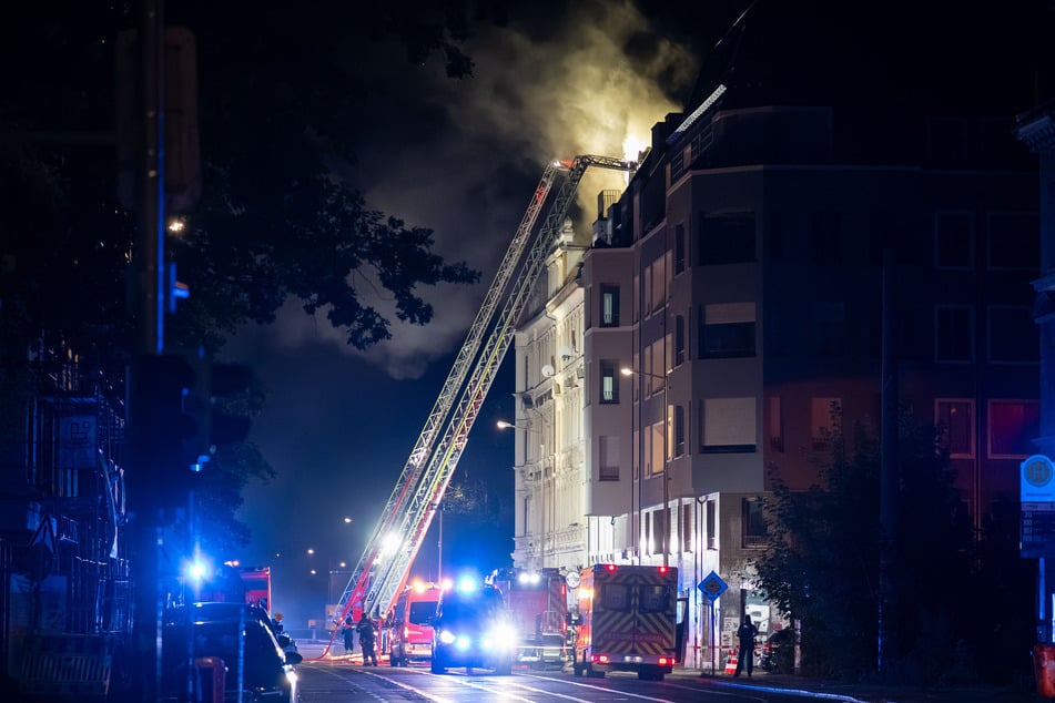 Nach bisherigen Erkenntnissen war das Feuer in der Küche einer Dachgeschosswohnung entstanden. Von dort griff es offenbar auf den Dachstuhl über.