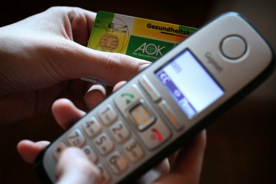 Gesundheitskarte in der Hand, zum Telefon gegriffen und beim Arzt angerufen: Das genügt meist weiterhin zur Krankschreibung. (Symbolbild).