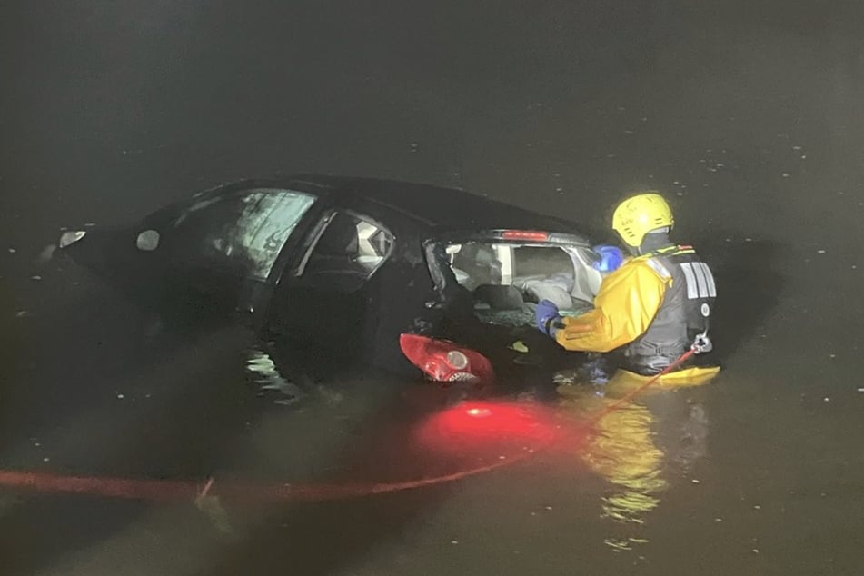 Mit vollem Körpereinsatz wurde der schwarze Peugeot aus dem Wasser geholt.