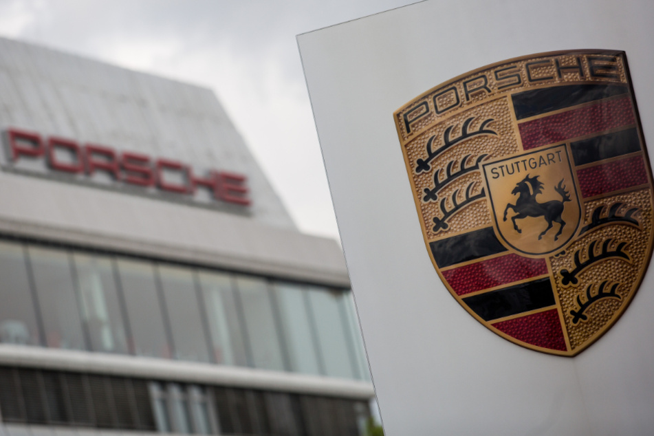 Das Porsche Logo ist vor einem Gebäude des Automobilherstellers zu sehen.