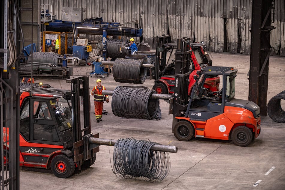 Gabelstapler transportieren im Werk Spulen von aufgerolltem Rundstahl.