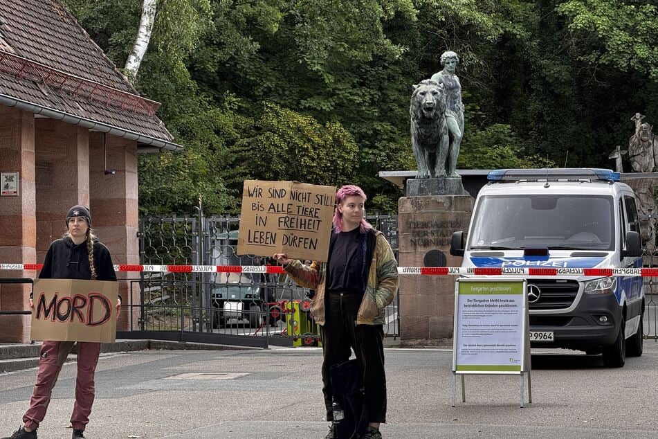 Aktivisten mit Plakaten positionierten sich am Dienstag vor dem geschlossenen Zoo-Eingang.