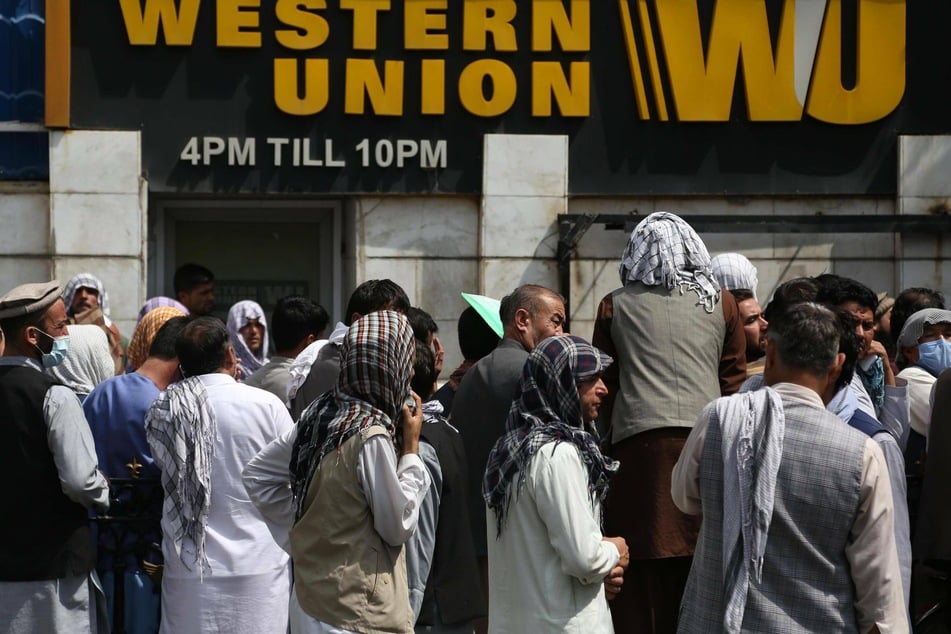 People line up in front of a bank in Kabul.
