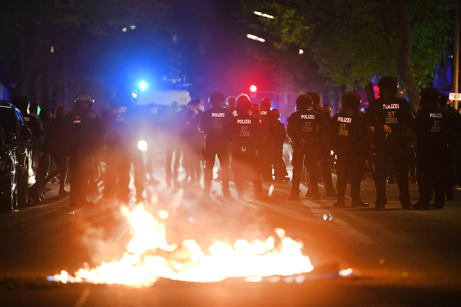 Polizei am Rande der Demonstration linker und linksradikaler Gruppen unter dem Motto "Demonstration zum revolutionären 1. Mai", im Vordergrund ein Feuer auf der Straße.
