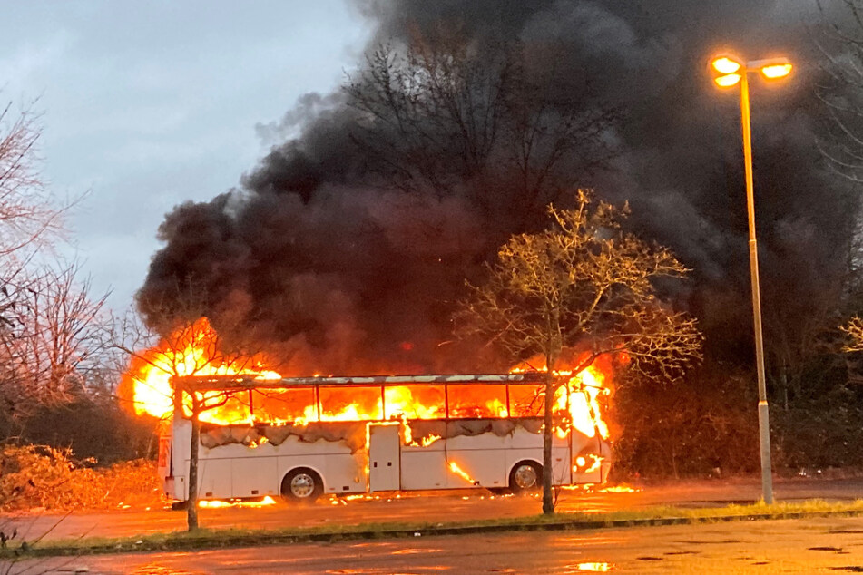 Der Reisebus auf dem Parkplatz eines Frankfurter Bowlingcenters steht lichterloh in Flammen. Infolge des Brandes entwickelte sich eine dichte Rauchwolke, die kilometerweit zu sehen war.