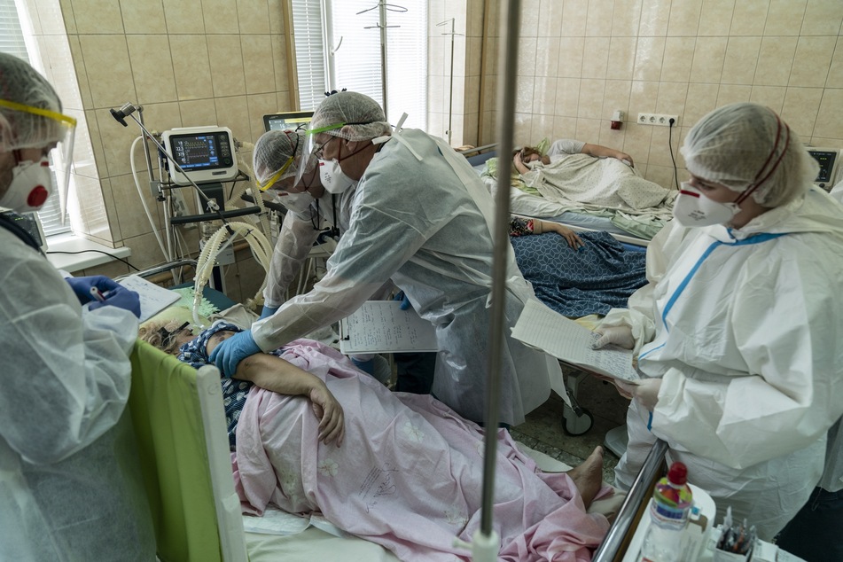 Mediziner in Schutzkleidung behandeln eine Patientin, die mit dem Coronavirus infiziert ist, auf der Intensivstation eines regionalen Krankenhauses in der Ukraine.