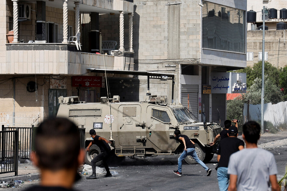 Palestinians clash with Israeli forces amid an Israeli military operation in Jenin.