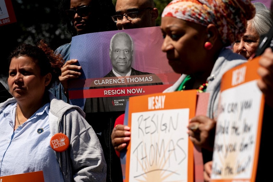 Activists hold signs calling on Supreme Court Justice Clarence Thomas to resign during a rally in Washington DC.