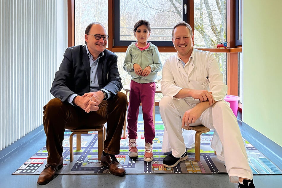 Bethanien-Geschäftsführer Michael Veihelmann (l.) und Oberarzt Dr. Fabian Kübler verabschieden die kleine Fatima (7).