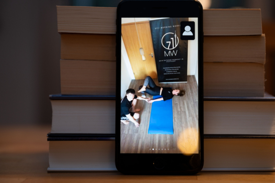 An einem Bücherstapel lehnt ein Handy.