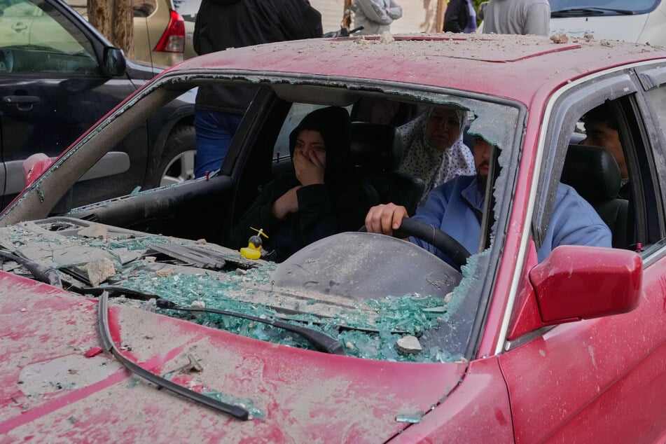 Sidon: Familienmitglieder sitzen in einem beschädigten Auto, als sie nach einem israelischen Luftangriff auf ein Wohnhaus fliehen.
