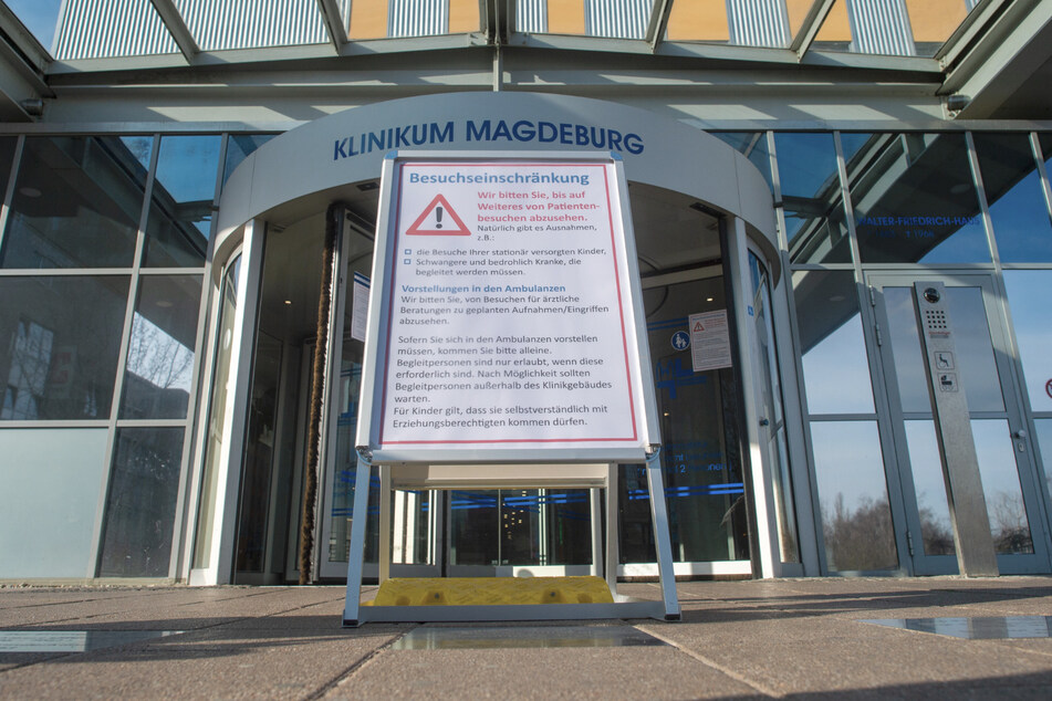 Ein Schild steht vor dem Haupteingang des Klinikums Magdeburg auf dem die Überschrift "Besuchseinschränkung" zu lesen ist. (Archivbild)