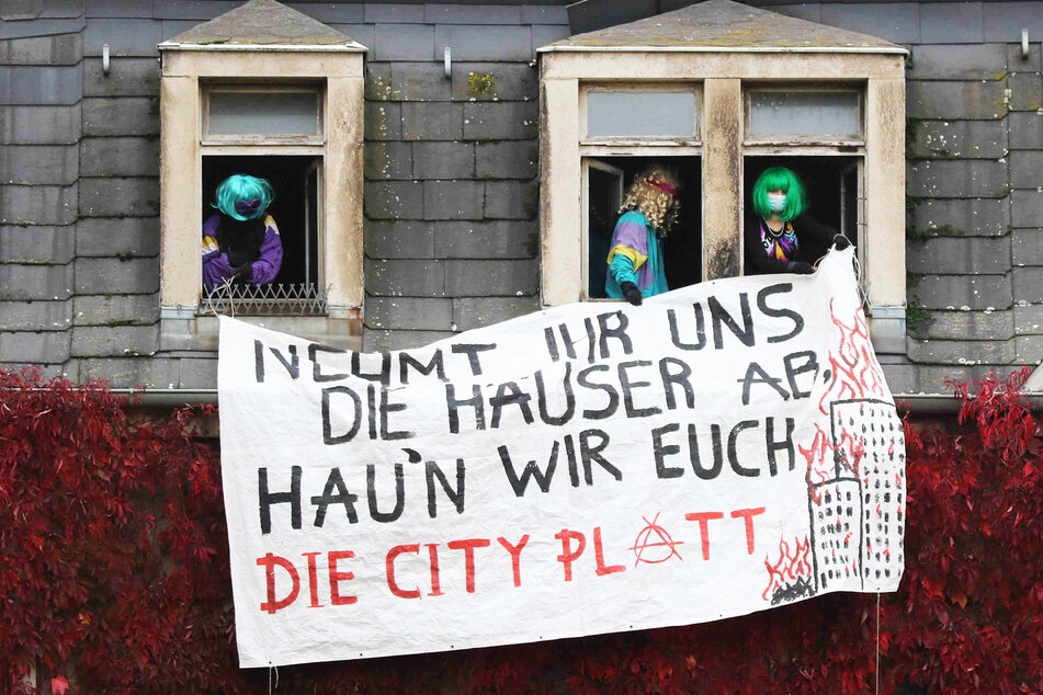 Die Aktivisten haben mehrere Plakate an dem Mehrfamilienhaus aufgehängt.