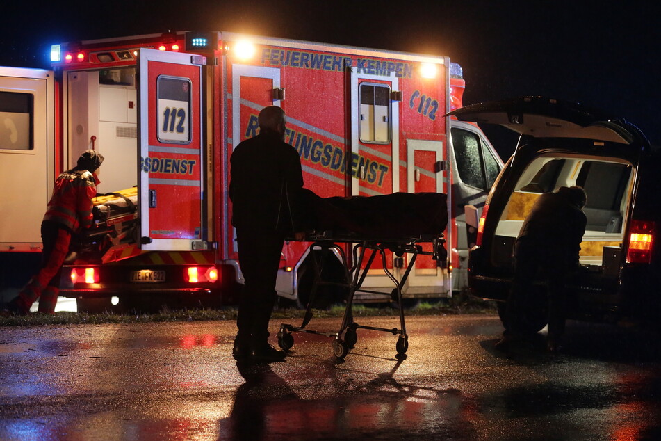 Bestatter verladen das Unfallopfer in einen Leichenwagen.