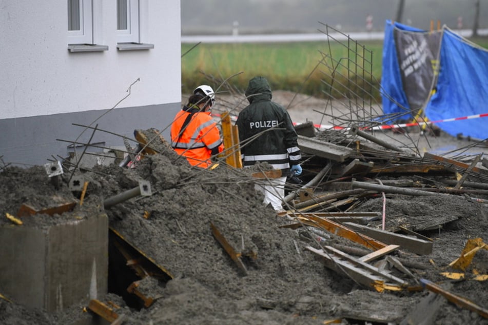 Polizeibeamte untersuchen eine Baustelle. Vier Arbeiter sind dort beim Einsturz einer Betondecke getötet worden.