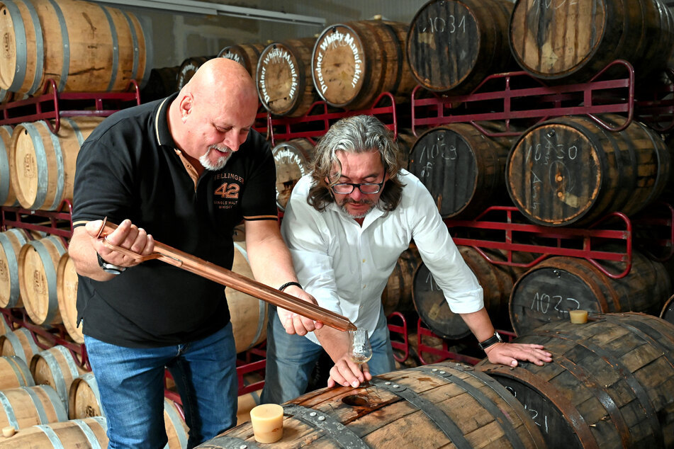 Die Inhaber der Dresdner Whisky Manufaktur, Thomas Michalski (63, l.) und Frank Leichsenring (61), zapfen eine Genussprobe aus dem Whiskyfass ab.