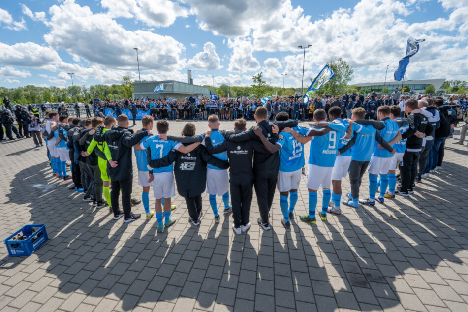 Die Mannschaft von 1860 München steht nach der bitteren Niederlage vor ihren mitgereisten Fans.