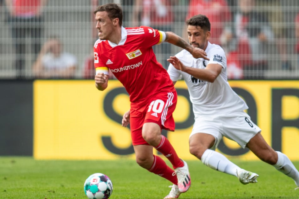 Unions Max Kruse (l.) kämpft mit Rani Khedira vom FC Augsburg um den Ball.