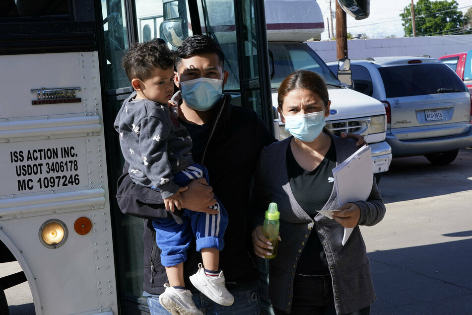 A migrant family arrives on a Border Patrol bus for processing at a shelter.