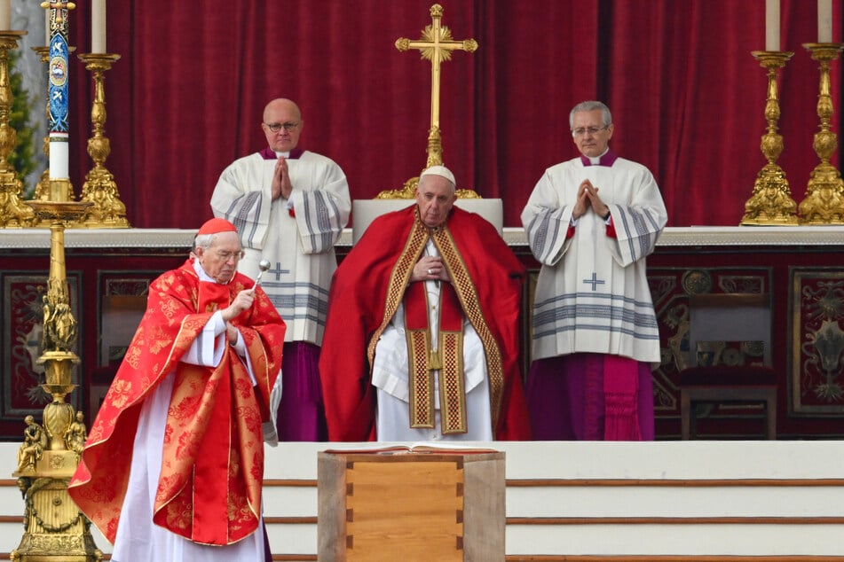 Kardinal Giovanni Battista Re (88, l.) segnet den Sarg des verstorbenen Papstes. Der amtierende Papst Franziskus (86, M.) steht dem Begräbnis vor.