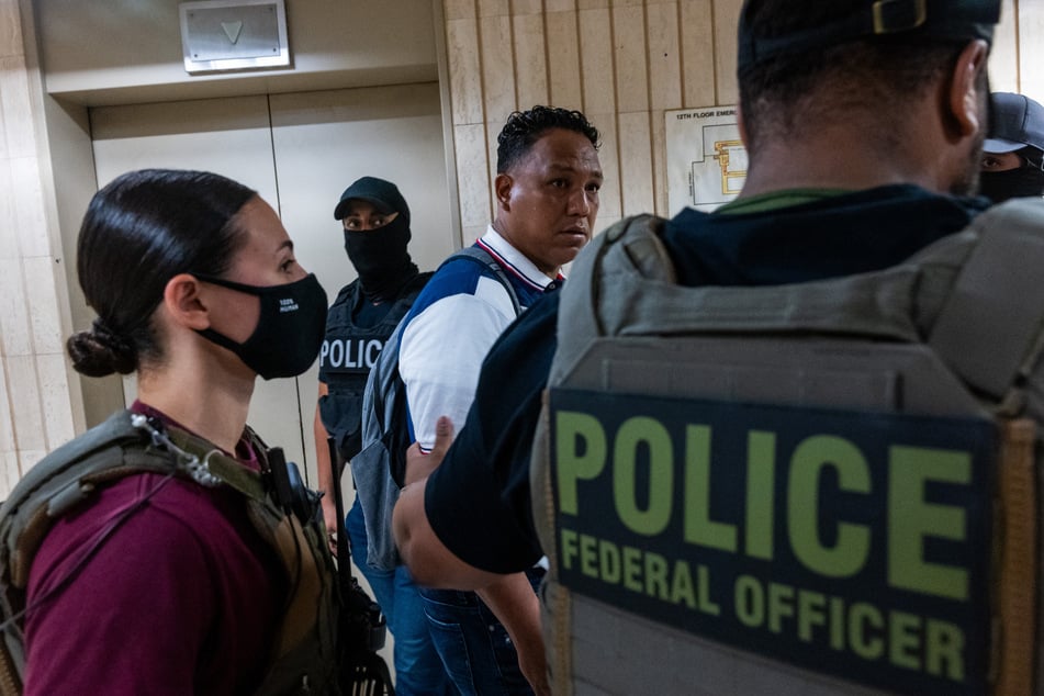 Federal agents detain a man as they patrol the halls of immigration court at the Jacob K. Javits Federal Building in New York City on July 8, 2025.