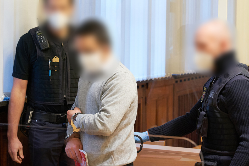 Der Angeklagte betritt mit Handschellen den Gerichtssaal im Oberlandesgericht. Ihm wird die Mitgliedschaft in einer ausländischen terroristischen Vereinigung - der PKK - vorgeworfen.