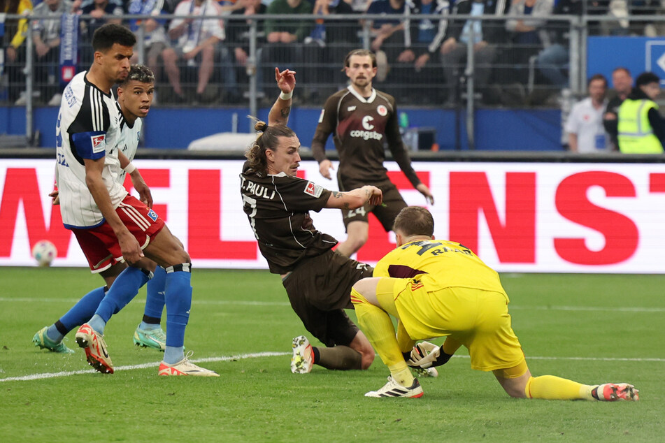 Da fehlte nicht viel: HSV-Keeper Matheo Raab (r.) entschärft die Situation, nachdem St. Paulis Jackson Irvine (M.) die Kugel verpasst hatte.