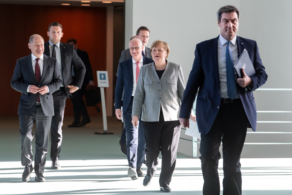 Bundeskanzlerin Angela Merkel (2.v.r., CDU) kommt zusammen mit Olaf Scholz (l, SPD), Bundesfinanzminister, Markus Söder (r, CSU), Ministerpräsident von Bayern, und Peter Tschentscher (M, SPD), Erster Bürgermeister von Hamburg zu einer Pressekonferenz im Bundeskanzleramt.