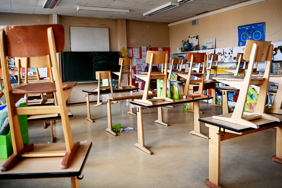 Stühle stehen in einer Schule auf den Tischen.