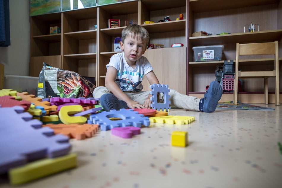 Dylan (5) baut im Spielzimmer der Kinderarche ein Haus aus Puzzleteilen. Er lebt seit acht Monaten in der Einrichtung.