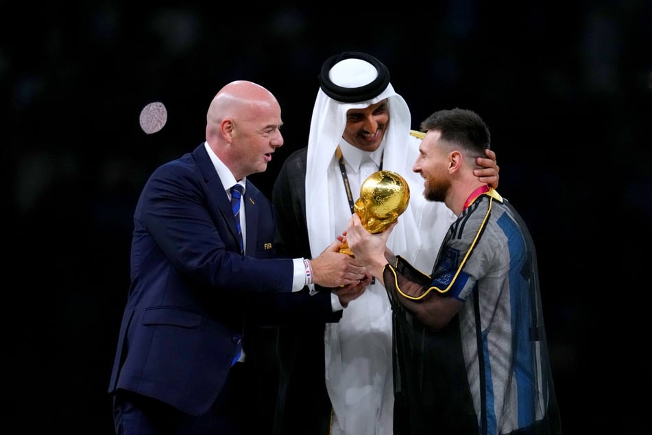 Bei der Vergabe des WM-Pokals standen nicht nur die Trophäe und der Weltmeister Lionel Messi (35, r.) im Vordergrund - auch ein ungewöhnliches, schwarzes Gewand erregte Aufmeerksamkeit.