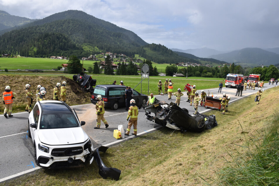Zahlreiche Rettungskräfte sind an der Unfallstelle bei Achenkirch an einer Straße nahe der Grenze zu Deutschland im Einsatz.