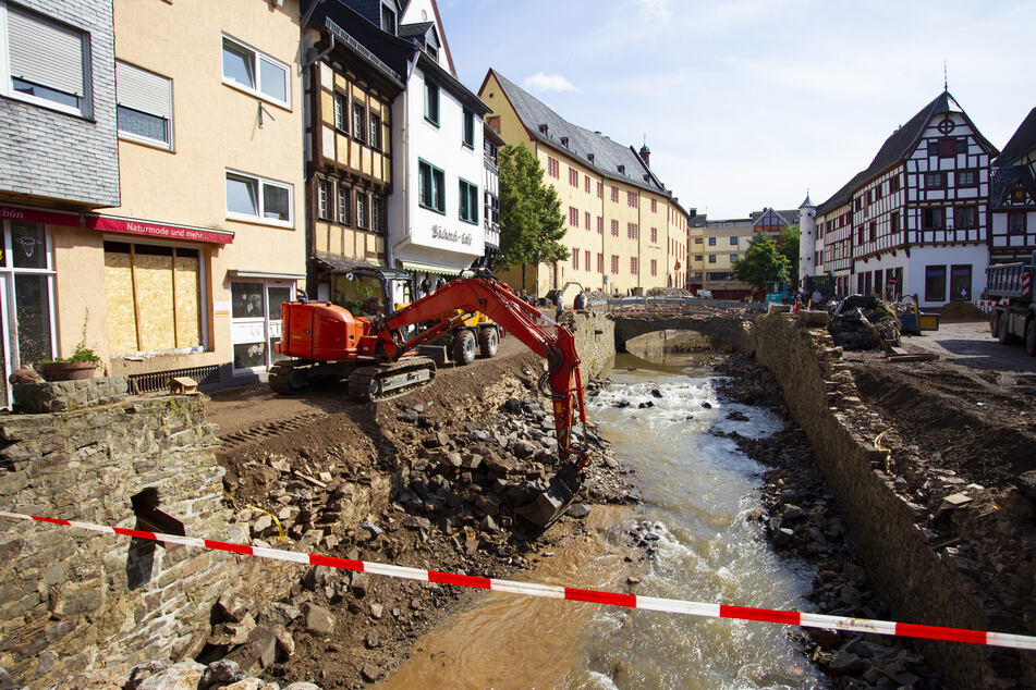In den betroffenen Gebieten laufen die Arbeiten auf Hochtouren: Im zerstörten Ort Bad Münstereifel kommt ein Bagger am Flüsschen Erft zum Einsatz.