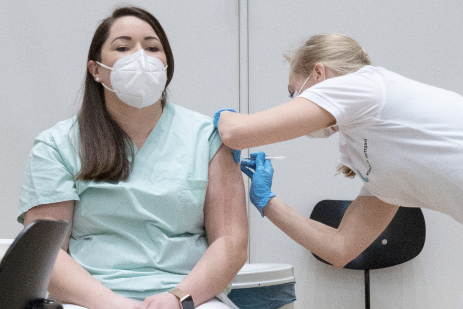 Eine Pflegekraft wird im Impfzentrum des Klinikum Stuttgart von einer Ärztin geimpft.