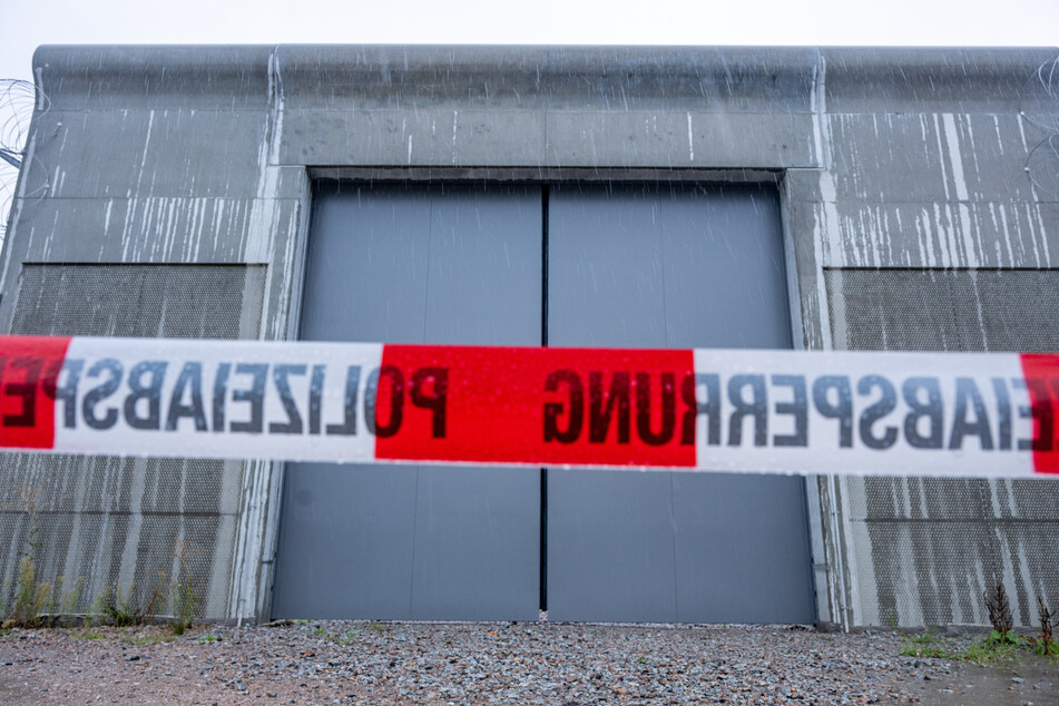 Ein Absperrband der Polizei ist vor einem Tor des Bezirkskrankenhauses Straubing angebracht. Vier Männer waren im niederbayerischen Straubing aus der geschlossenen Klinik entflohen.