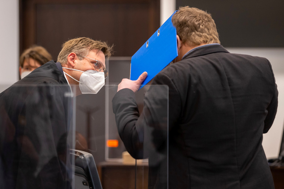 Ein wegen versuchten Mordes angeklagter Mann (r.) unterhält sich im Sitzungssaal im Strafjustizzentrum des Landgerichts Nürnberg-Fürth zu Prozessbeginn mit seinem Anwalt Franz Heinz.