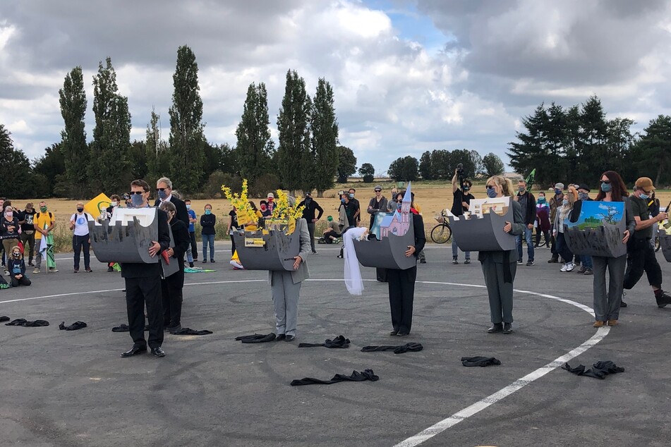 Teilnehmer der Demo zeigen beispielhaft auf, was für den Kohleabbau in der Region weichen musste.