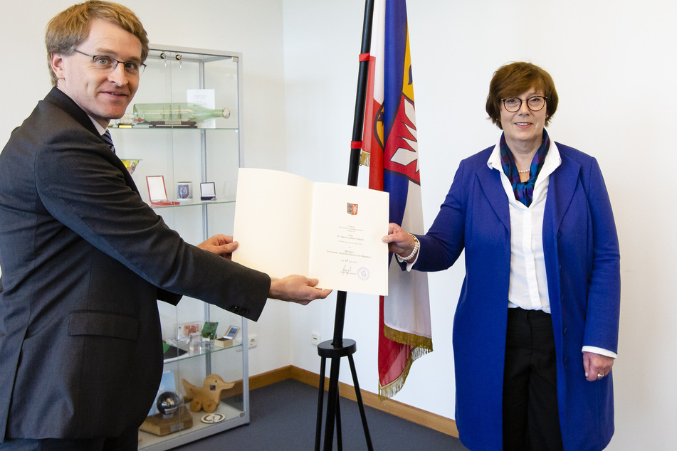 Der Ministerpräsident von Schleswig-Holstein, Daniel Günther (l, CDU), und die neue Innenministerin Sabine Sütterlin-Waack (CDU), präsentieren mit großem Abstand die Ernennungsurkunde für die bisherige Justizministerin.
