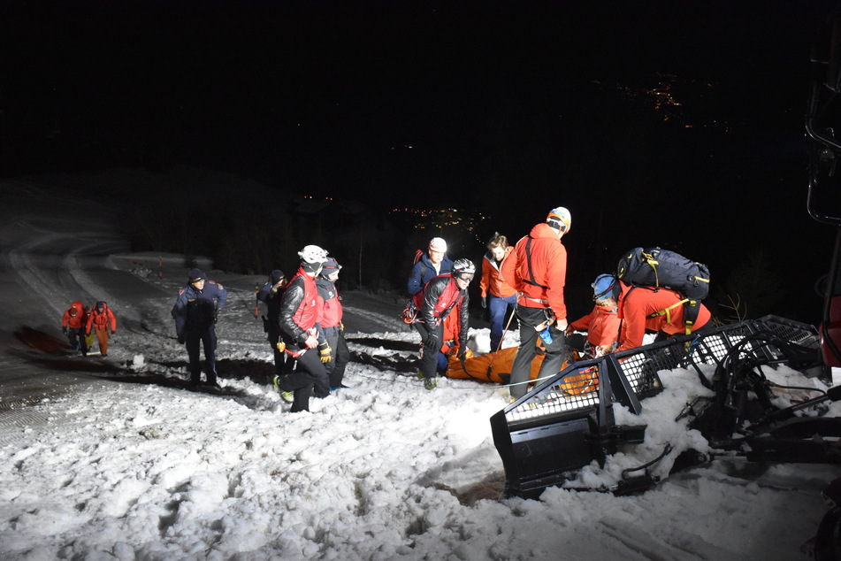 Einsatzkräfte der Bergrettung und Polizei kümmern sich um die Verletzten.