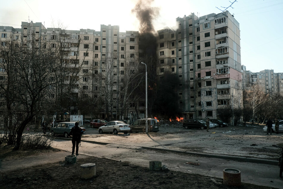 Soldaten und Polizisten untersuchen die Folgen einer Rakete, die in der Nähe eines Wohngebäudes in Kiew eingeschlagen ist, nachdem sie aus dem Himmel abgeschossen wurde.